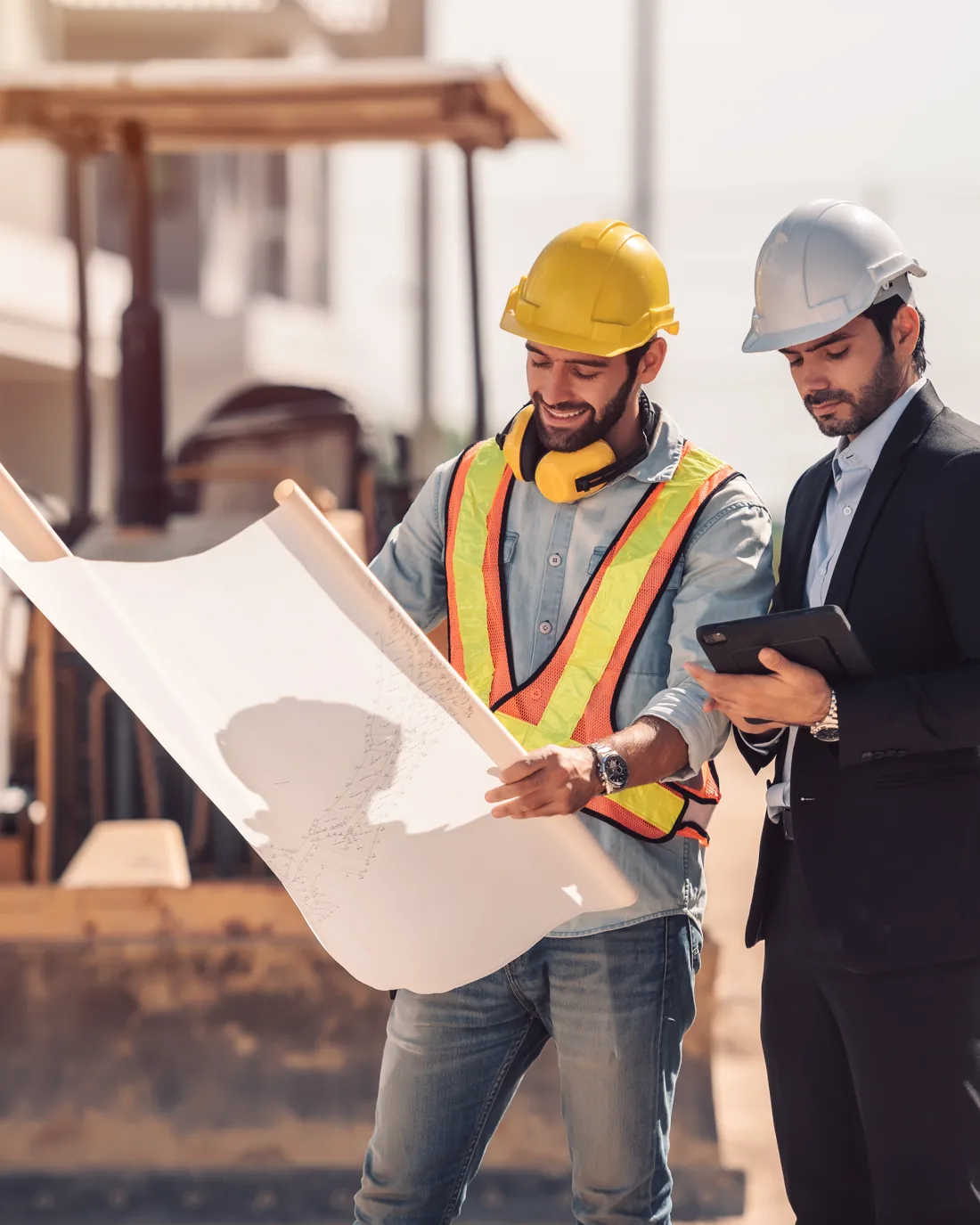 Engenheiro e gestor analisando planta na obra
